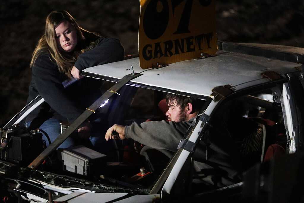 Cheyenne Frederick and Jacob Garnett try to fix Garnett’s car during a heat
